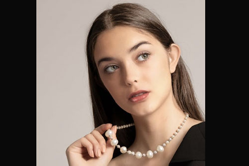 beautiful model posing and displayong pearl necklace
